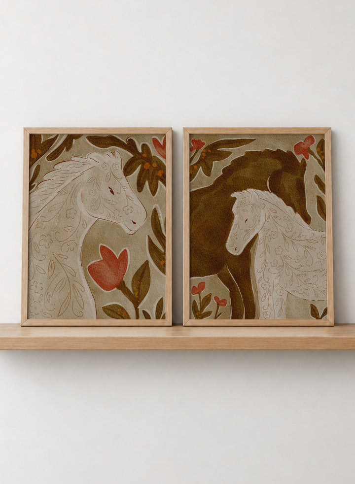 Two framed art prints depicting stylized horses in warm earthy tones. Shop Wildflower Horses by Nikita Jariwala, a set of 2 horse wall art prints posters featuring floral horse portraits, botanical details, and warm brown tones.