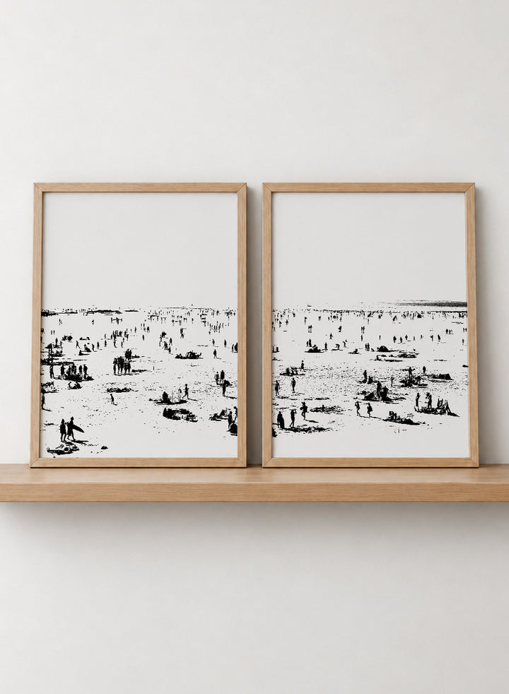 Shop Beach No.02 by Dan Hobday, a set of 2 black and white beach wall art prints posters featuring a panoramic shoreline filled with tiny figures.