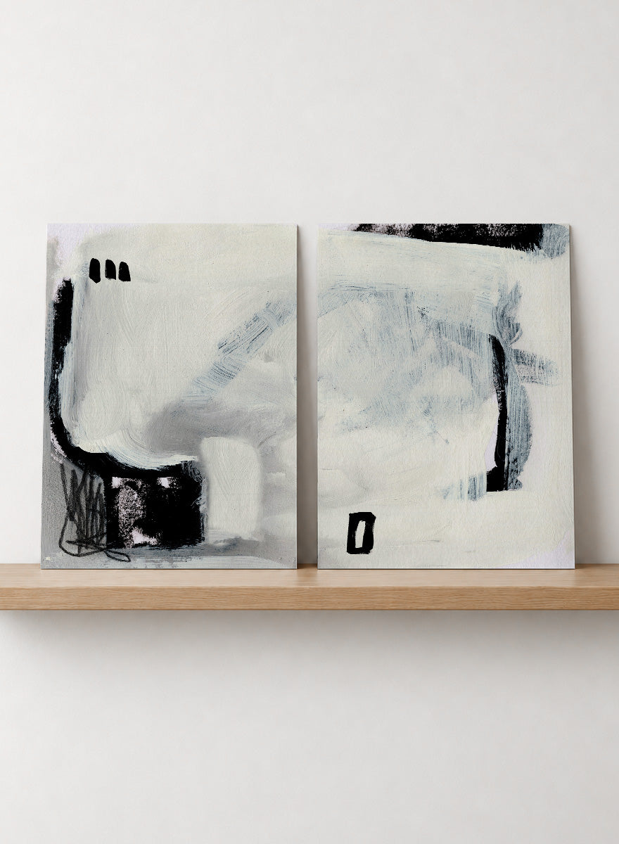 Shop Beyond by Dan Hobday, a set of 2 abstract wall art prints posters featuring expressive black forms, layered brushwork, and soft white and blue tones.