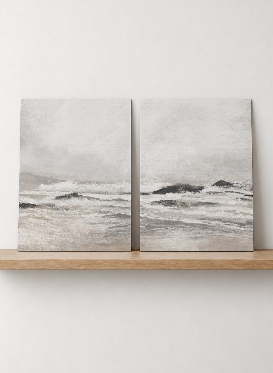 Shop September Coast by Dan Hobday, a set of 2 coastal wall art prints posters featuring rolling waves, dark rocks, misty skies, and soft neutral tones.