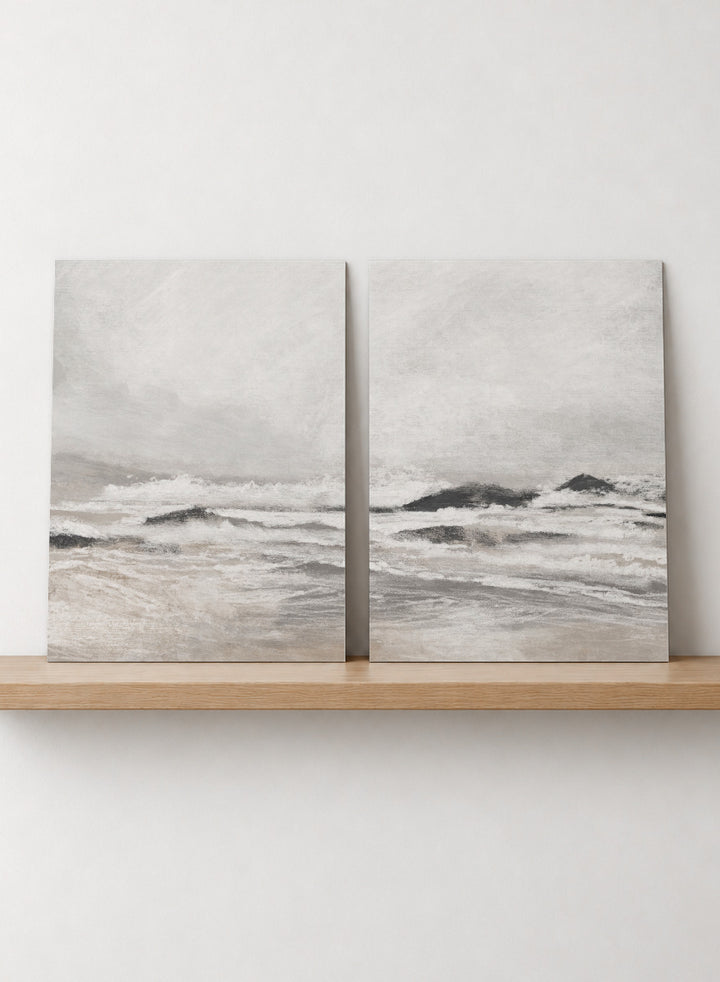 Shop September Coast by Dan Hobday, a set of 2 coastal wall art prints posters featuring rolling waves, dark rocks, misty skies, and soft neutral tones.
