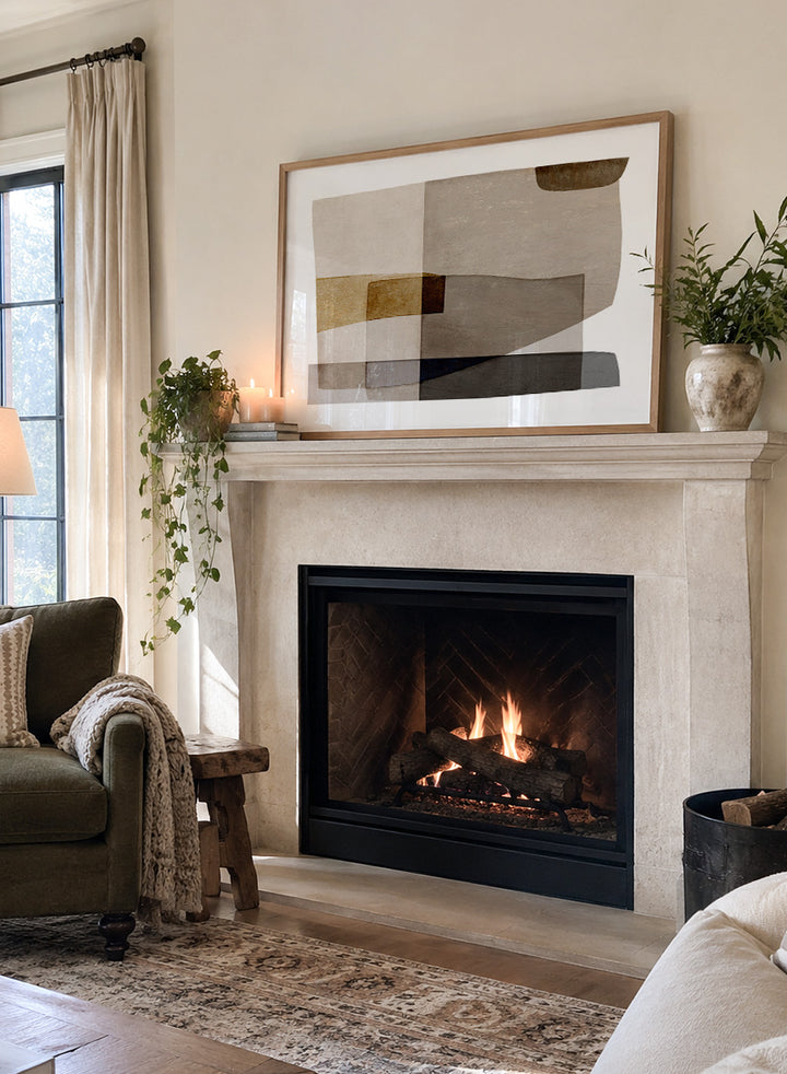 Framed abstract wall art featuring layered geometric shapes in beige, taupe, brown, gray, and black on a white mat, shown against a light warm gray background. Shop Transform by Dan Hobday, a contemporary abstract wall art print featuring layered geometric forms, soft brown and taupe tones, and textured neutral detail.