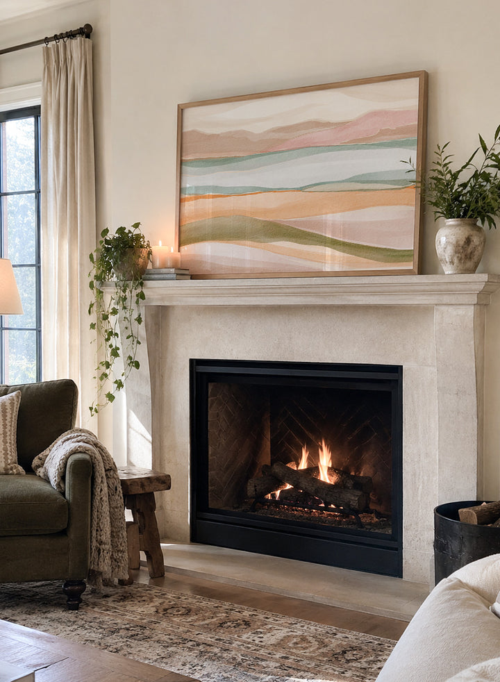 Framed abstract landscape art print featuring soft watercolor hills and layered fields in pastel peach, pink, sage green, cream, and light blue. Shop Calm Watercolor Landscape by Nikita Jariwala, an abstract landscape wall art print poster with rolling hills, mountain scenery, watercolor layers, and soft green tones.