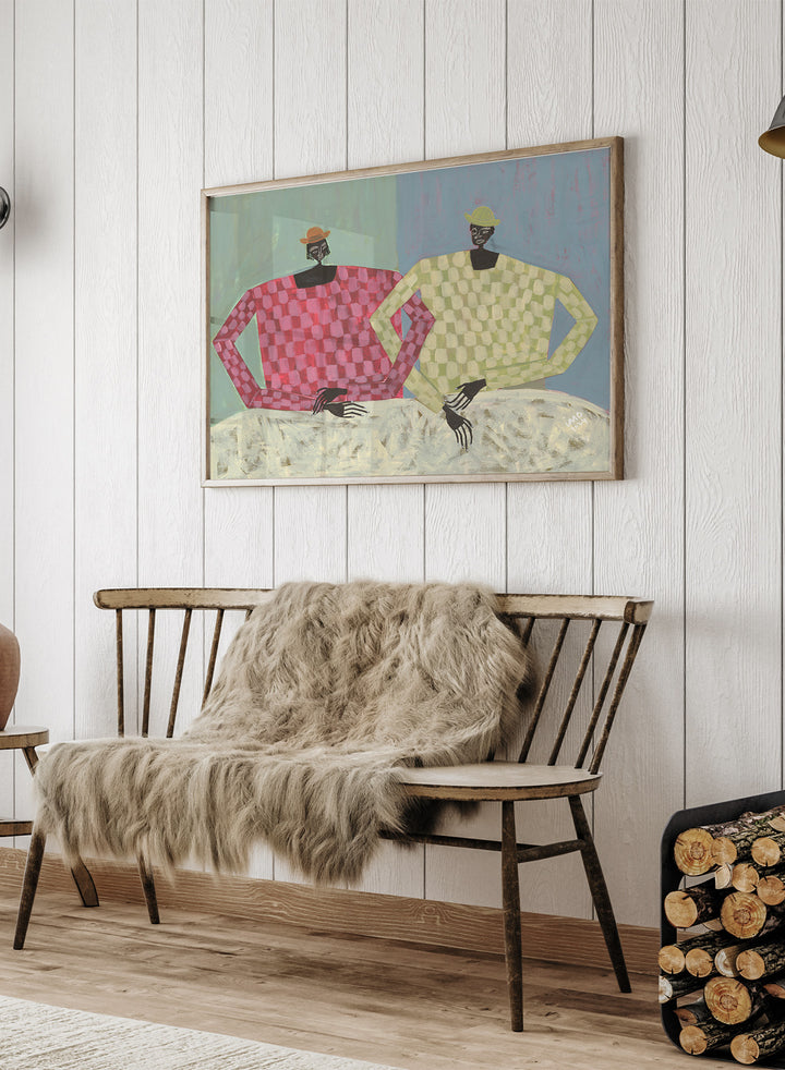 Framed artwork of two figures wearing colorful sweaters against a textured background. Opposites by Studio IMO (Ibi Meier-Oruitemeka) is a modern figurative art print with two figures, bold color contrast, and contemporary wall poster design.