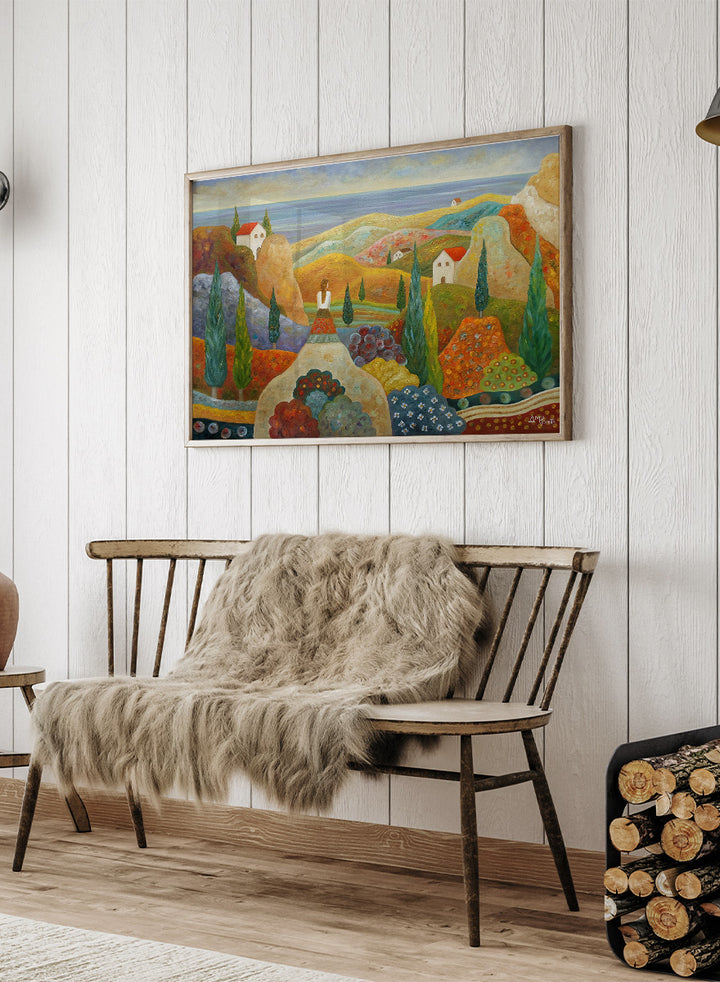 A framed landscape painting featuring stylized hills, cypress trees, small houses with red roofs, and a blue sea under a pale sky. Shop Woman in Mediterranean Landscape by Angeles M. Pomata, a colorful Mediterranean landscape and figurative art print with cypress trees, white houses, hills, and sea views.
