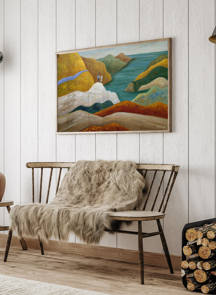 A framed landscape painting featuring stylized coastal cliffs, hills, and a body of water in earthy yellow, orange, green, blue, and white tones. Shop Couple Overlooking Coastal View by Angeles M. Pomata, a coastal landscape and figurative art print featuring a couple, rolling hills, and a blue sea view.