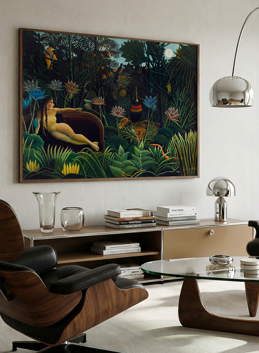 A framed art print depicting a lush, surreal jungle scene with a reclining nude woman in a boat, colorful flowers, birds, and animals under a full moon. The Dream by Henri Rousseau is a vintage jungle art print featuring a reclining woman, lush tropical plants, lions, flowers, and a moonlit forest.