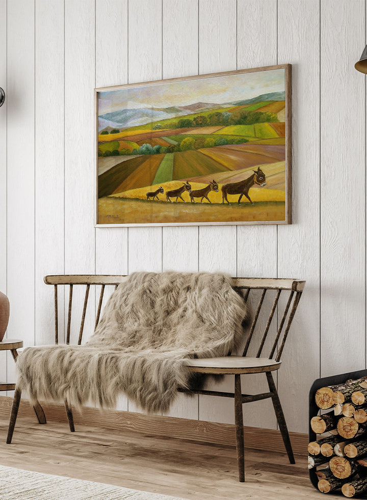Shop Donkey Family Journey by Angeles M. Pomata, an autumn animal and countryside art print featuring a family of donkeys, patchwork fields, and rolling hills.