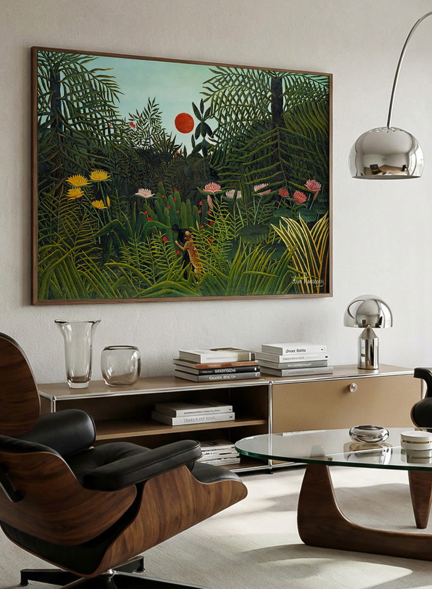 A framed art print depicting a lush, stylized jungle scene with dense green foliage, a small figure, and a bright red sun against a pale sky. Virgin Forest with Sunset by Henri Rousseau is a vintage jungle art print featuring lush tropical foliage, bright flowers, wildlife, and a red setting sun.