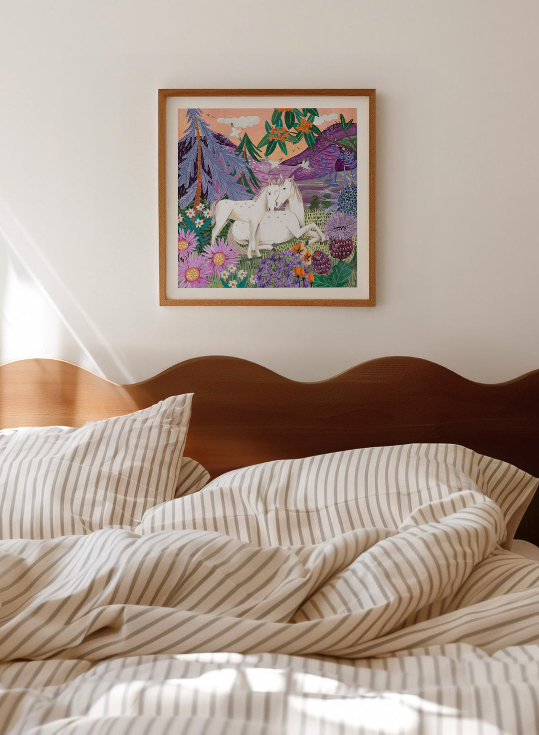 Framed artwork of two horses in a colorful forest scene with flowers and mountains. Horses in the Mountains by Caroline Bonne Müller is a fine art print and wall poster featuring two white horses surrounded by colorful flowers in a mountain landscape.