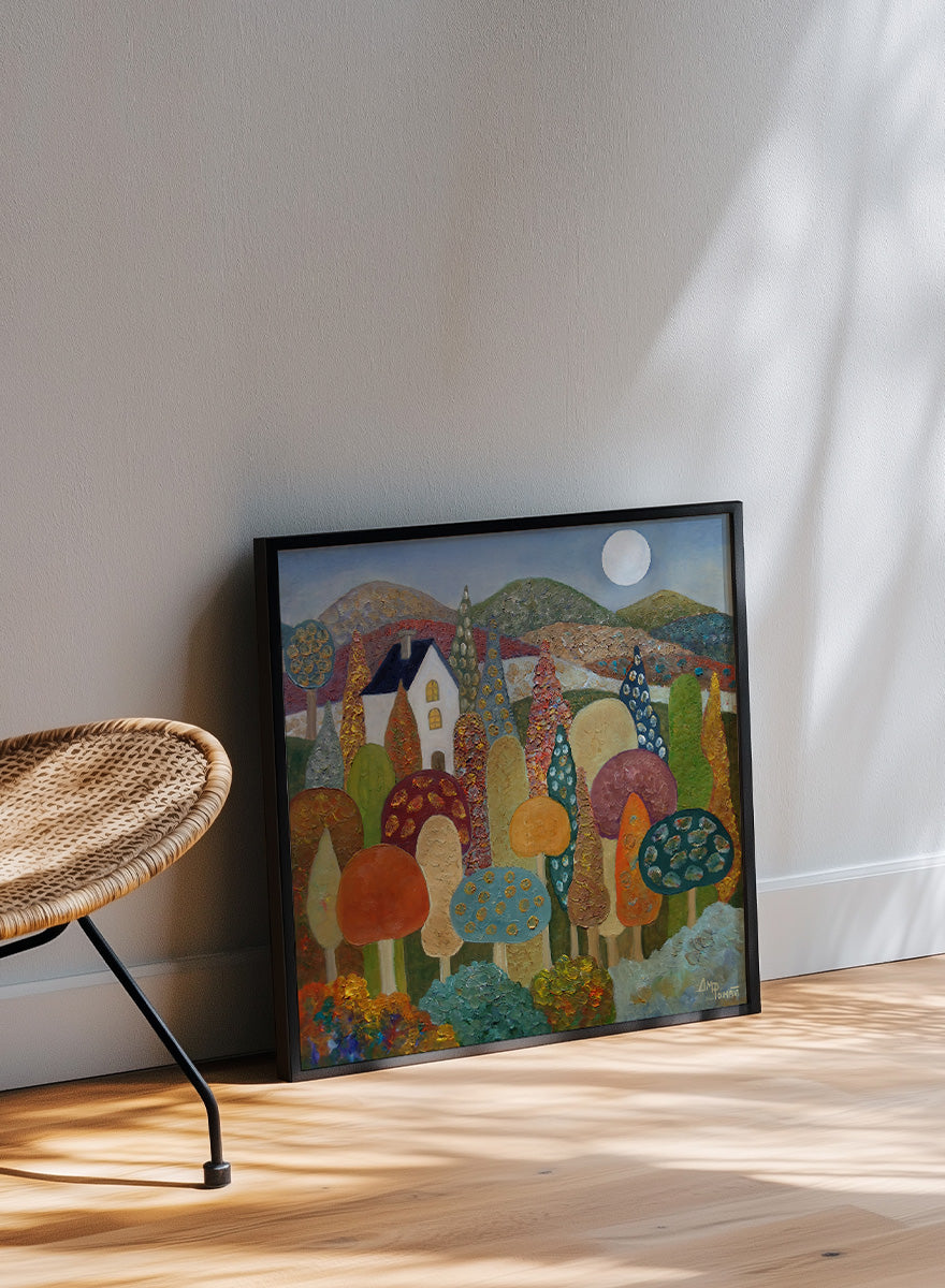 A framed folk-art style landscape painting featuring stylized mushrooms, trees, hills, a small house, and a full moon. Shop Whimsical Moonlit Landscape by Angeles M. Pomata, a colorful autumn landscape art print featuring a white house, full moon, rolling hills, and stylized trees.