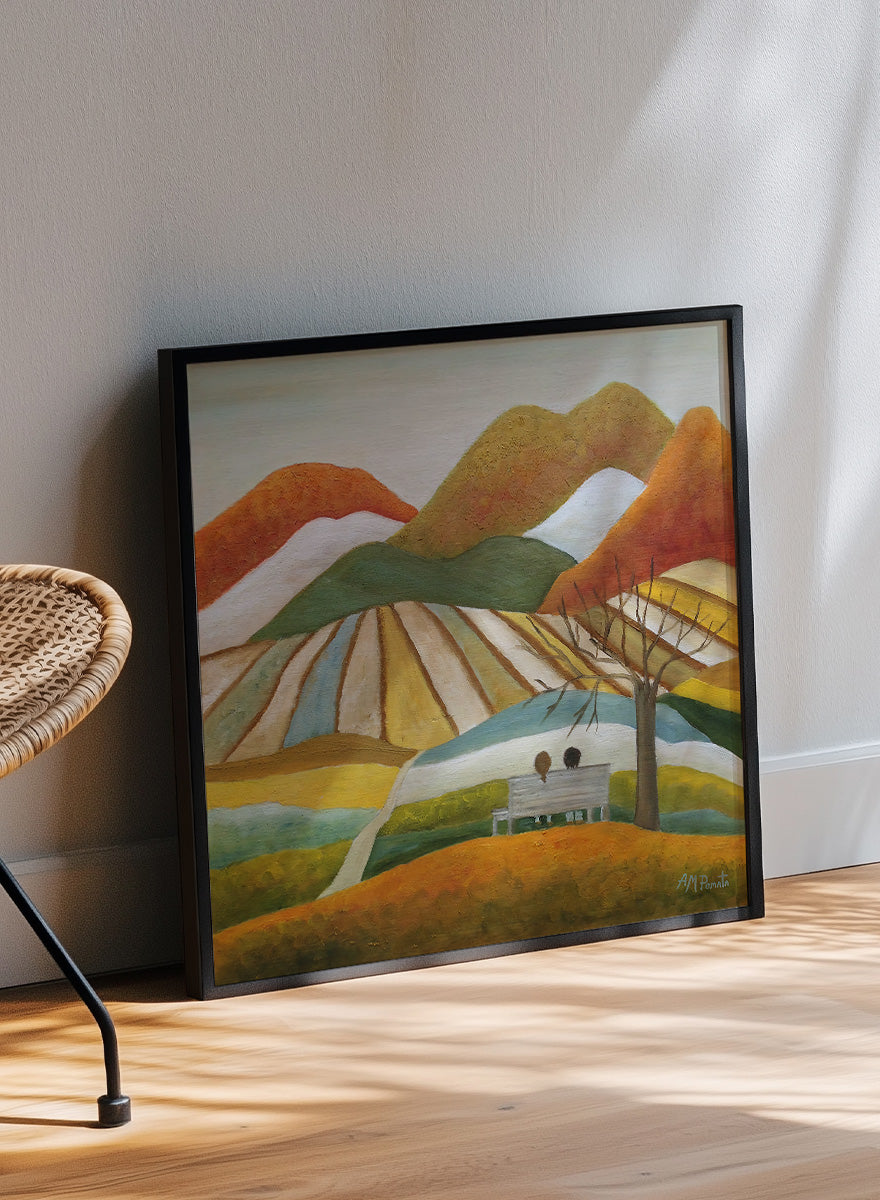 A framed landscape painting featuring stylized mountains, striped fields, a bench with two figures, and a bare tree. Shop Couple On Autumn Bench by Angeles M. Pomata, an autumn landscape and figurative art print featuring a seated couple, rolling hills, patchwork fields, and warm fall tones.