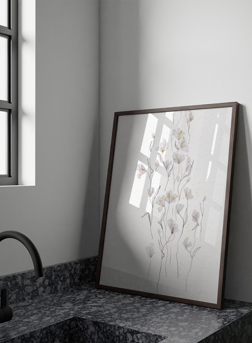 A framed watercolor painting of delicate white and light gray flowers with thin stems on a textured white background. Shop Delicate Gold Flowers by Ankie Kooi, a floral wall art print poster with airy botanical stems, soft gray flowers, yellow accents, and line art.