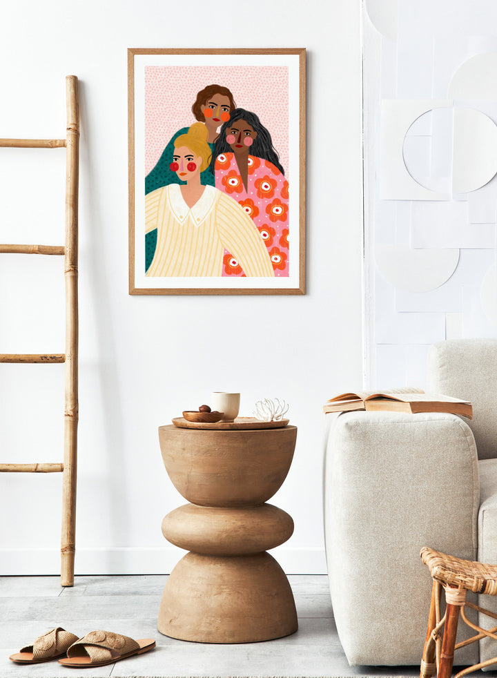 Illustration of three women with colorful clothing and patterns on a pink background. Girl Friends by Bea Müller is an officially licensed art print featuring three women illustrated in her signature bold colors and modern expressive style.