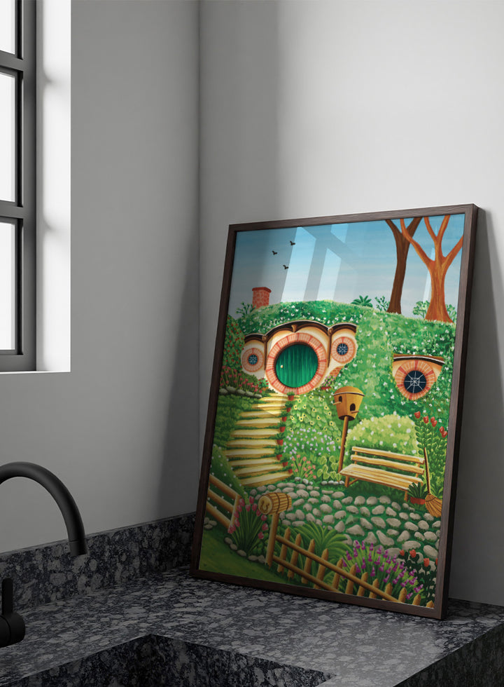 A colorful fantasy-style illustration of a hobbit hillside scene with a round green door, stone steps, flowers, trees, a bench, and a birdhouse under a blue sky. Shop Whimsical Hill House by Nidhi Kachhadiya, a colorful cottage wall art print featuring a garden home, lush greenery, flowers, and playful storybook details.