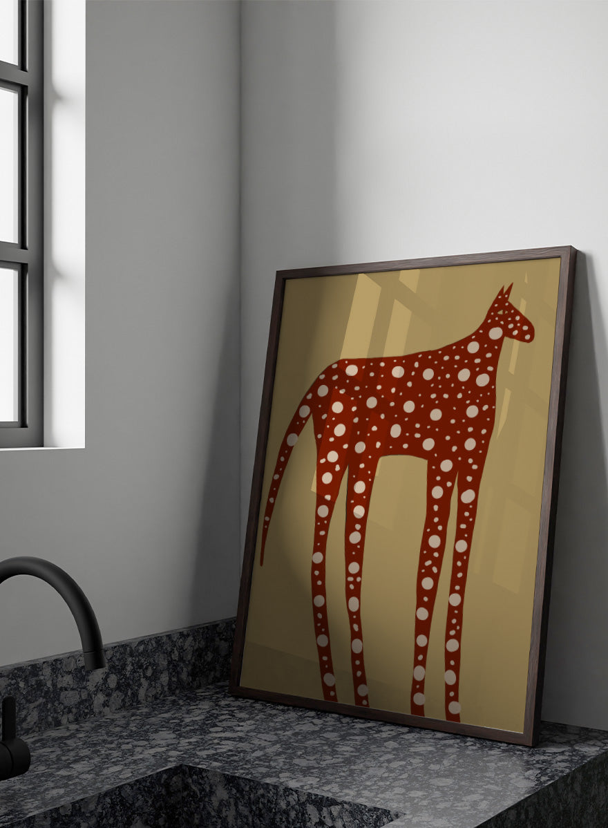 A stylized art print of a giraffe in reddish-brown with white spots, set against a tan background. Spotted Earthy Creature by The Art Concept animal art print featuring a long-legged rust-colored figure with cream spots on a muted tan background.