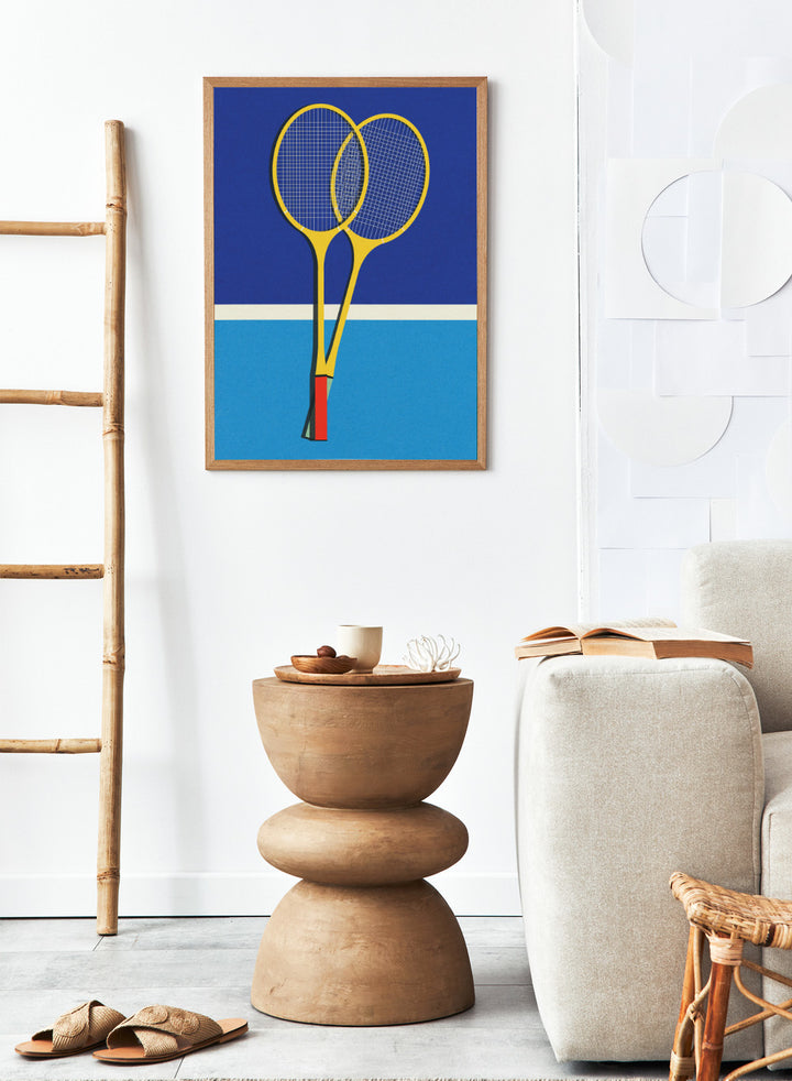 Two yellow badminton rackets on a blue background with a white stripe at the bottom. Wooden Badminton Rackets by Rosi Feist is a modern minimalist fine art print featuring bold yellow rackets on a graphic blue court. Officially licensed wall poster with optional artisan framing.