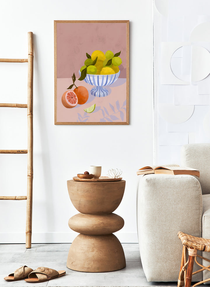 Illustration of a bowl with lemons and limes on a pink background. Bittersweet by Goed Blauw is a still life art print and wall poster with lemons, limes, and grapefruit in a striped bowl on a soft pink background.