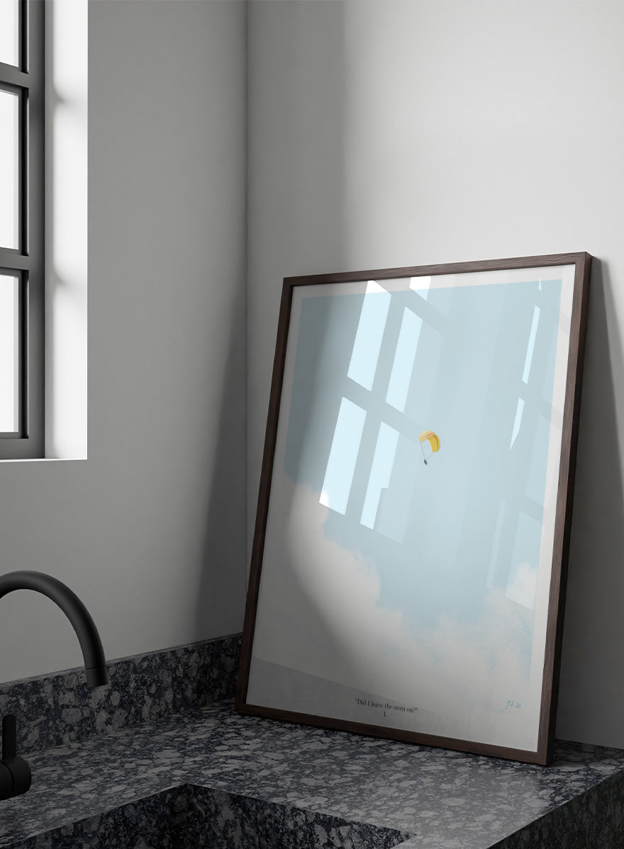 A minimalist art print featuring a light blue sky with white clouds and a small yellow-and-white parachute near the center, framed by a black border with the quote &