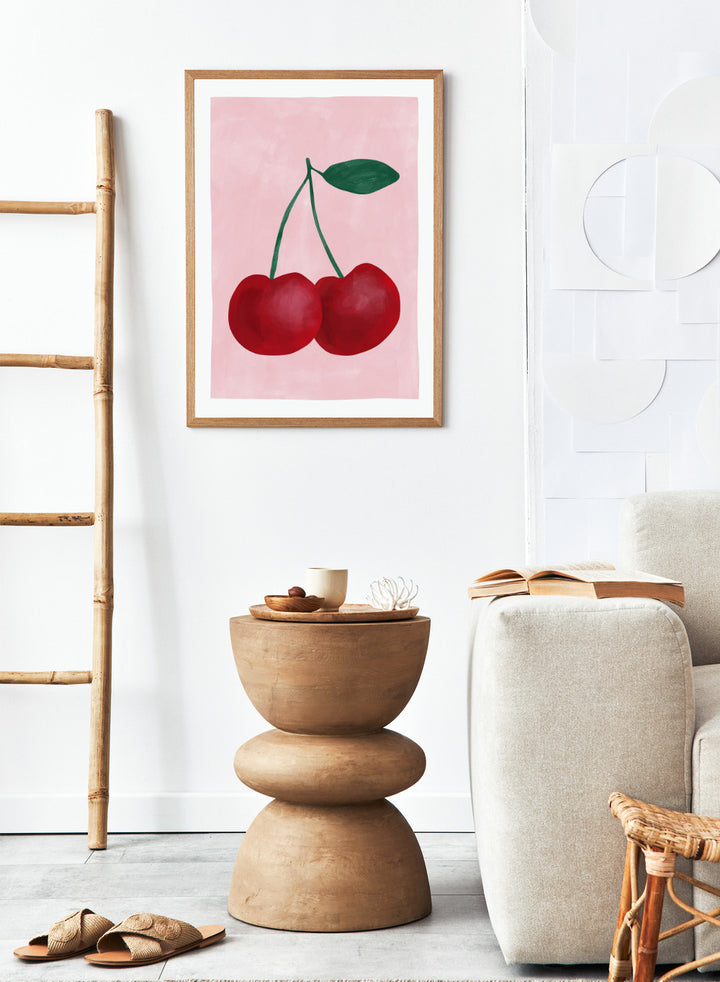 Two red cherries with a green stem on a pink background. Red cherries art print by Elena Ristova featuring two hand-painted cherries with green stems on a soft pink background. Officially licensed minimalist wall poster.
