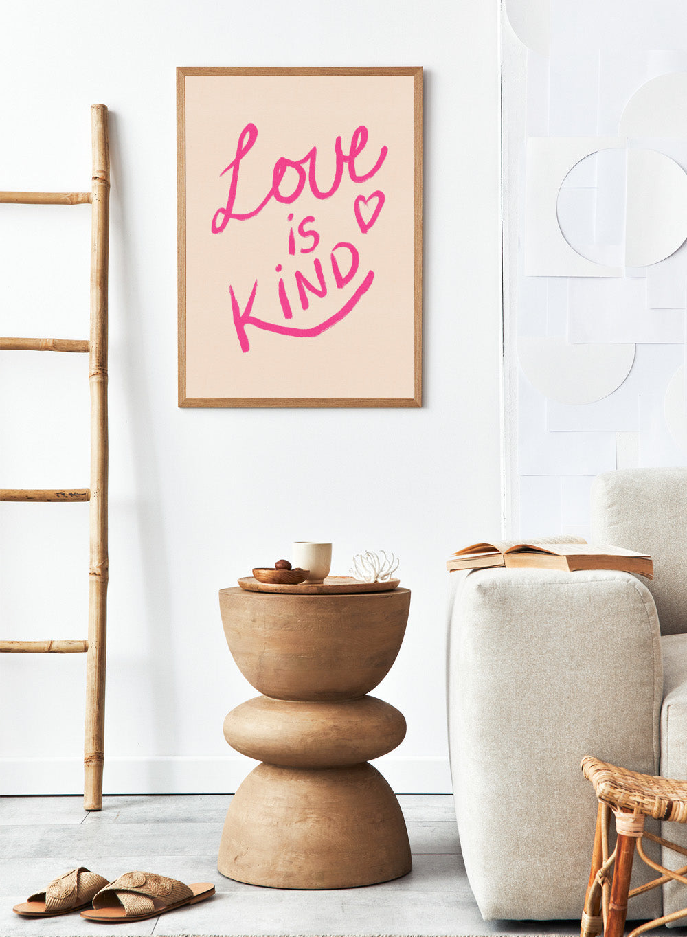 Pink text 'Love is Kind' with a heart on a light pink background. Love Is Kind by Dirkie Nell is a pink typography art print with handwritten lettering and heart detail. A joyful modern love wall poster.