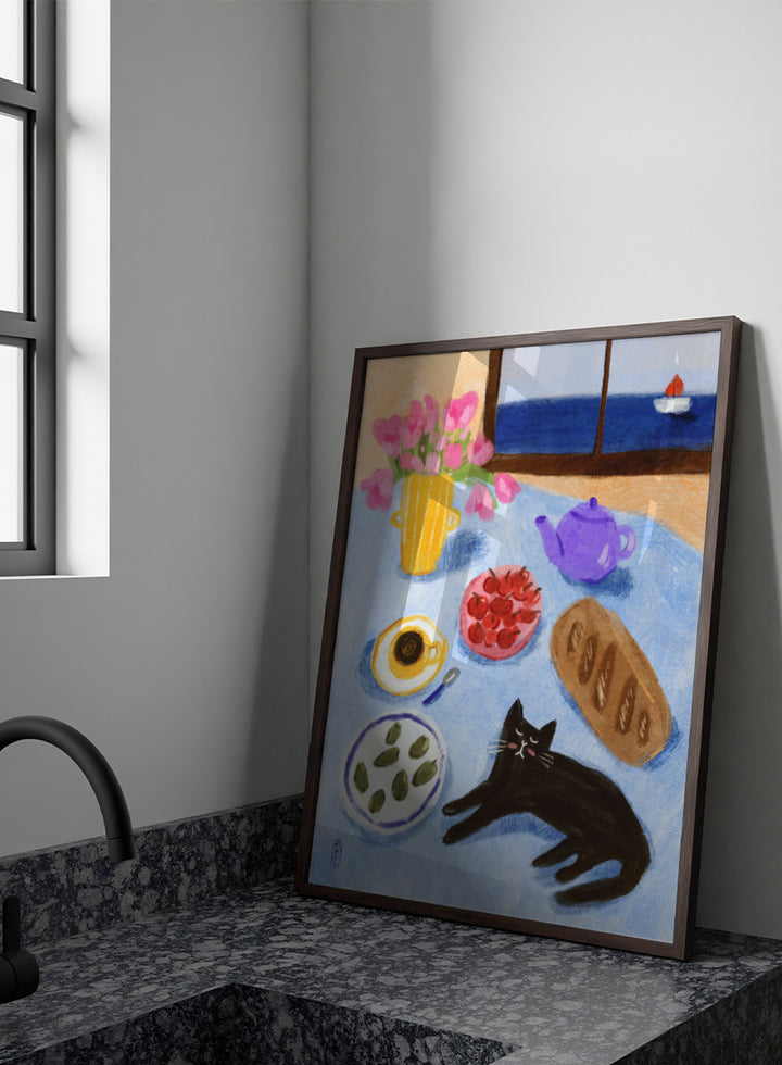 A colorful still life painting of a table scene with pink tulips in a yellow vase, a purple teapot, a bowl of strawberries, a cup of coffee, a loaf of bread, a black cat, and a window view of the sea with a small sailboat. Shop Relaxing Seaside Cat Breakfast by Dirkie Nell, a playful cat and food art print featuring breakfast, flowers, a sailboat, and a seaside view.