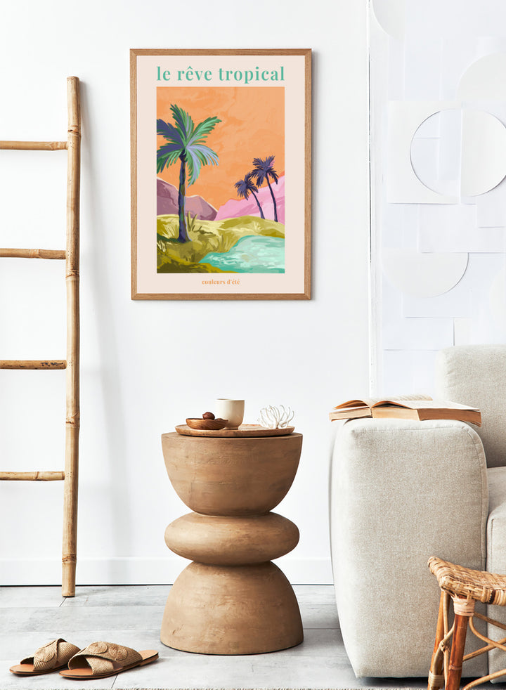Tropical landscape with palm trees and a lake, featuring the text 'le rève tropical' on an orange background. Le Rêve Tropical Palm Trees by Goed Blauw is a tropical landscape art print and wall poster featuring palm trees, hills, and water in warm sunset tones.