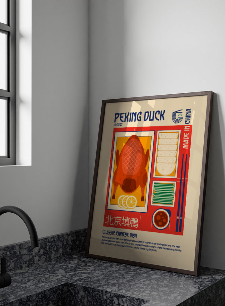 A stylized travel poster of Peking Duck, featuring a large illustration of a roasted duck, steamed buns, chopsticks, and a bowl of sauce on a beige background with red and blue graphic borders. Classic Peking Duck by Retrodrome retro kitchen art featuring Peking duck, pancakes, scallions, dipping sauce, Chinese typography, and bold vintage color.