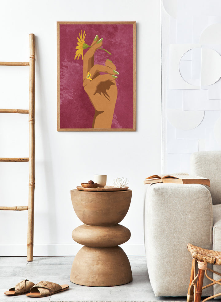 Illustration of a hand holding a yellow flower against a pink background. Smoking Flower by Raissa Oltmanns is a modern floral art print featuring a hand holding a yellow flower in bold contemporary wall poster style.