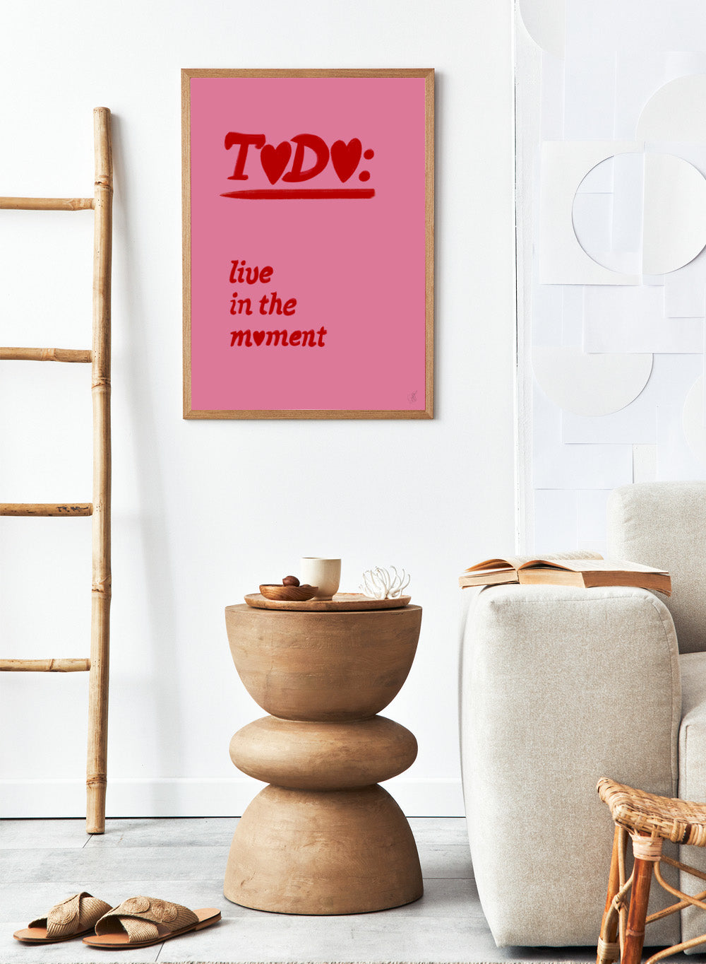 Pink poster with red text 'TODO: live in the moment' on a pink background. Typography wall art reading “live in the moment” with red hearts on pink background by Anne-Marie Volfova. Officially licensed motivational art print.