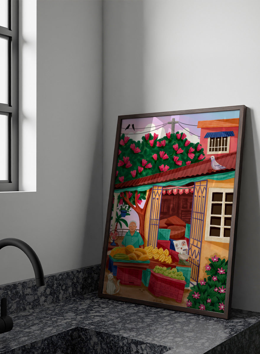 A colorful illustrated street market scene with a vendor standing behind tables of fruit and vegetables, a flowering tree, a house with pink flowers, crates, a pigeon on the roof, birds in the sky, and a white cat in the lower left. Colorful fruit stand art print by Nidhi Kachhadiya with fresh produce, floral details, and market charm. A cheerful print for kitchen or dining spaces.