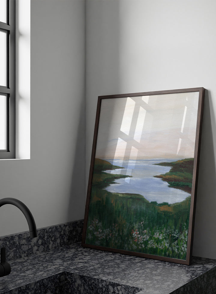 A landscape painting of a winding river or inlet between green hills, with a pale sky above and wildflowers in the foreground. Shop Wildflower Coast View by Nikita Jariwala, a coastal landscape wall art print poster featuring ocean views, green cliffs, wildflowers, and soft blue tones.