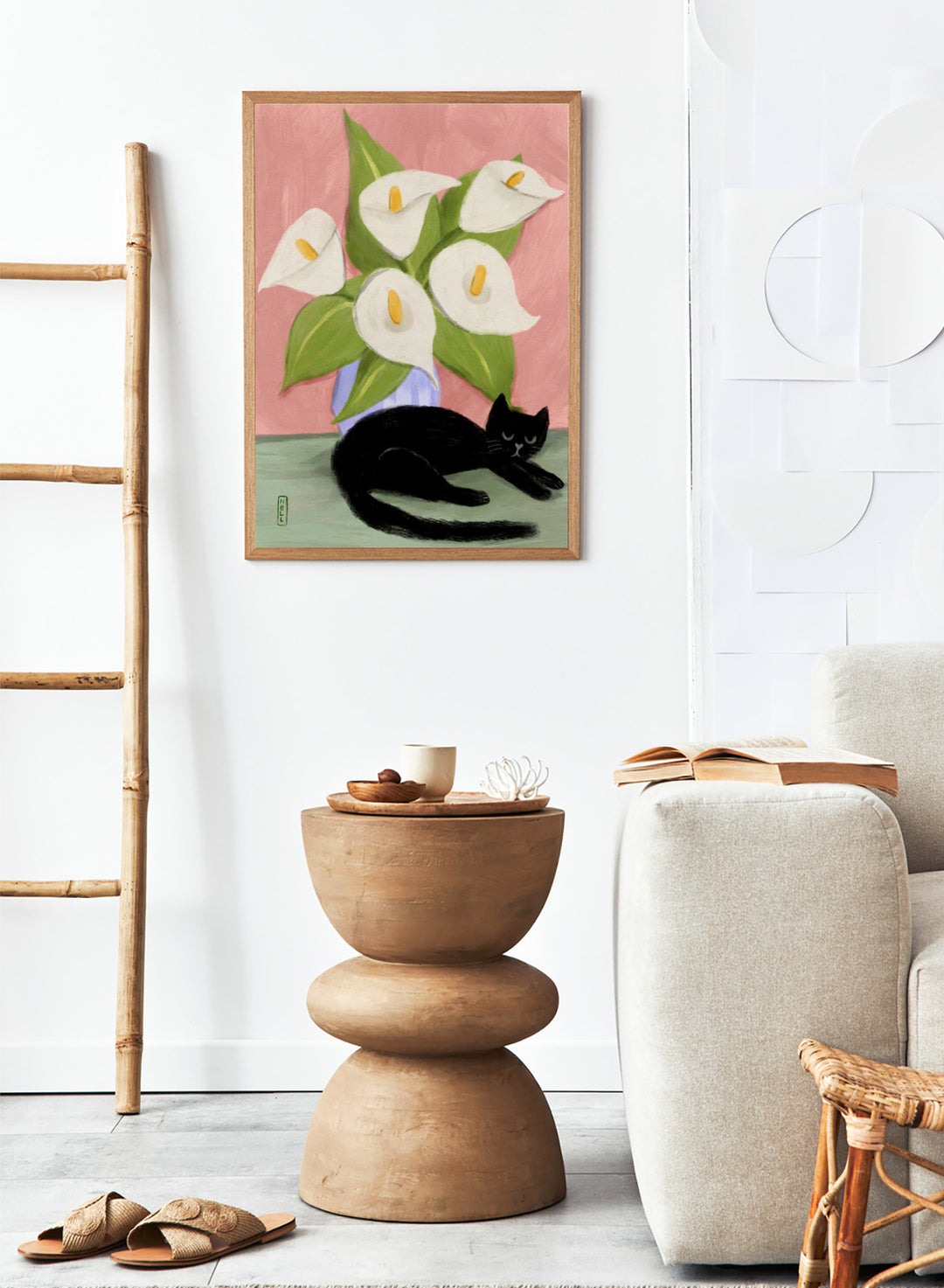 Black cat lying on a surface with white flowers in a blue vase against a pink background. Lilies In a Vase and a Black Cat by Dirkie Nell is a contemporary floral cat art print featuring hand painted lilies, soft pink tones, and playful still life illustration.