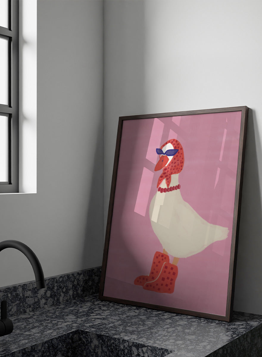 A stylized illustration of a white goose wearing a red patterned headscarf, blue sunglasses, a red beaded necklace, and red checkered boots, set against a solid pink background. Chic Goose Fashion by The Art Concept playful animal art print featuring a goose in sunglasses, a red headscarf, necklace, and bold red boots.
