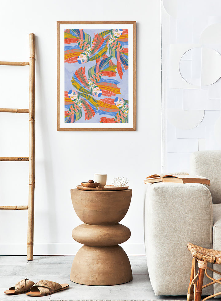 A framed art print featuring a colorful pattern of stylized fish with flowing striped fins in orange, yellow, green, blue, and red on a light blue background. Vibrant Swirling Fish Pattern by Ceyda Alasar art print featuring colorful flowing fish, striped fins, and playful aquatic movement on a soft blue background.