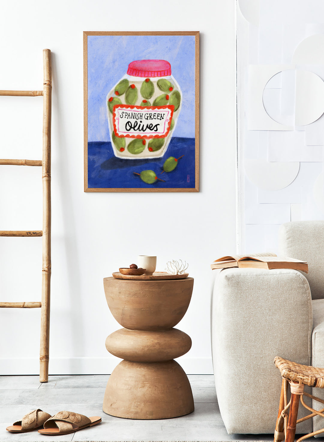 Illustration of a jar of Spanish green olives on a blue background. Spanish Green Olives Jar by Dirkie Nell is a playful food art print featuring hand painted olives, colorful kitchen details, and Mediterranean inspired design.