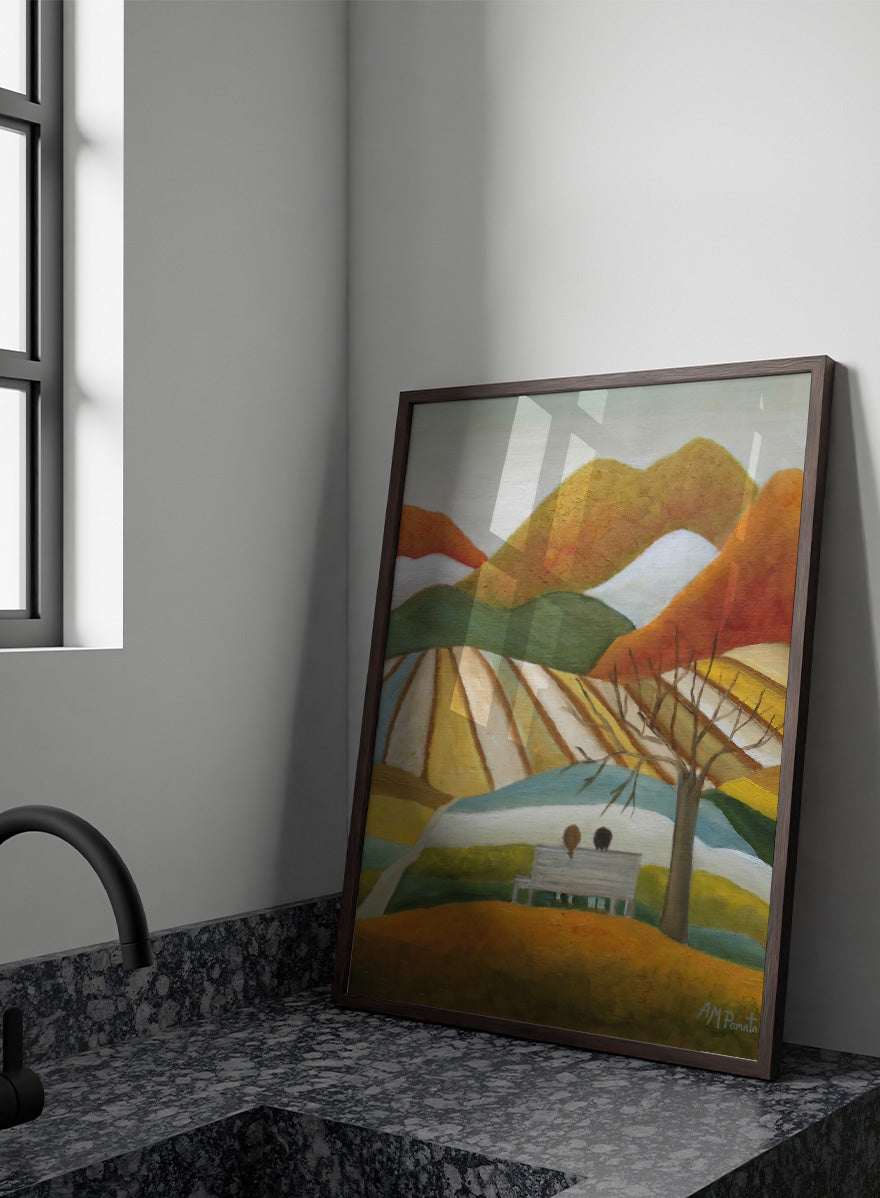 A stylized landscape painting with layered mountains, terraced fields, a bare tree, and two small figures seated on a bench in the foreground. Shop Couple On Autumn Bench by Angeles M. Pomata, an autumn landscape and figurative art print featuring a seated couple, rolling hills, patchwork fields, and warm fall tones.