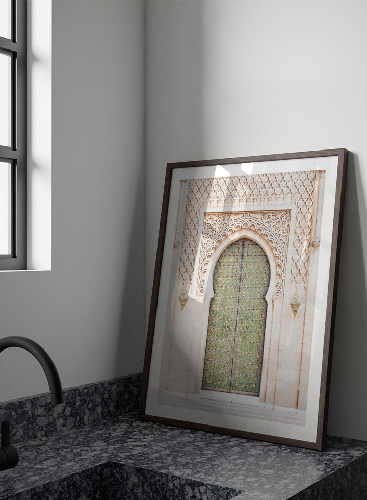 Decorative archway with ornate green door on a light stone wall. Ornate Moroccan Green Door by Henrike Schenk is a Moroccan architecture print featuring an ornate green door, Islamic patterns, and historic stone details.
