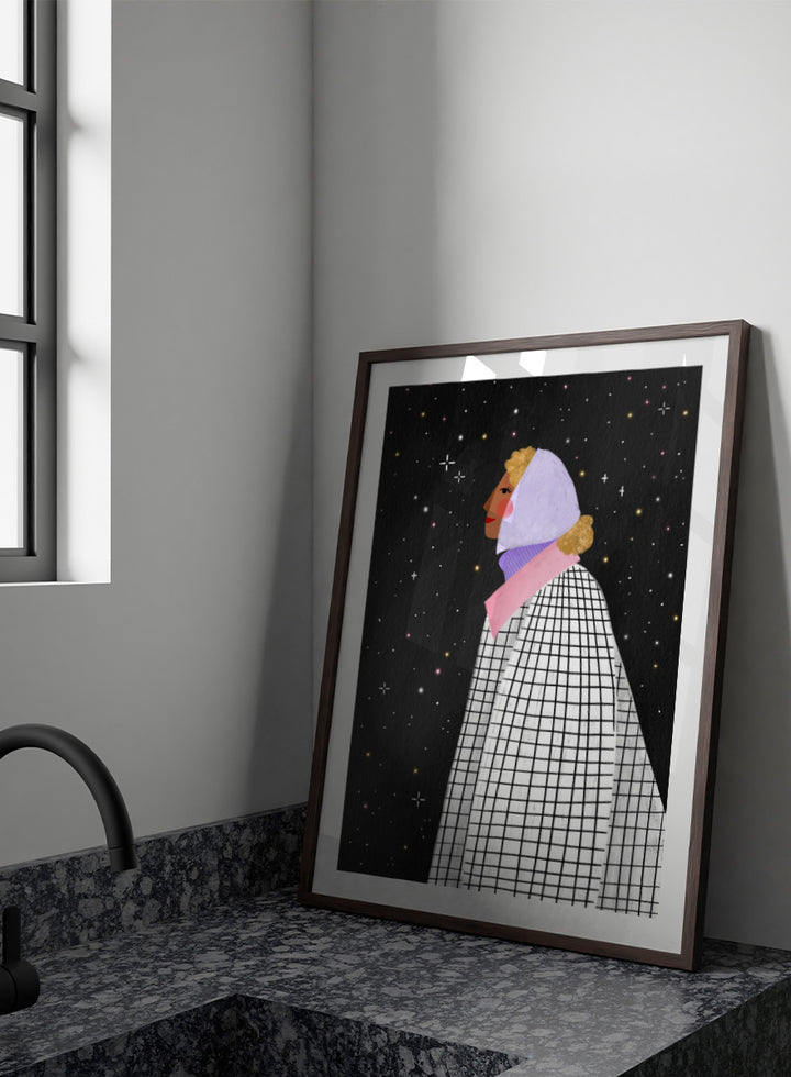 A framed art print featuring a stylized illustration of a woman in profile wearing a white and black checkered cape and a lavender headscarf against a black starry background. Shop Woman Under Starry Night by Bea Müller, a figurative wall art print poster featuring a contemplative woman beneath a star-filled black night sky.