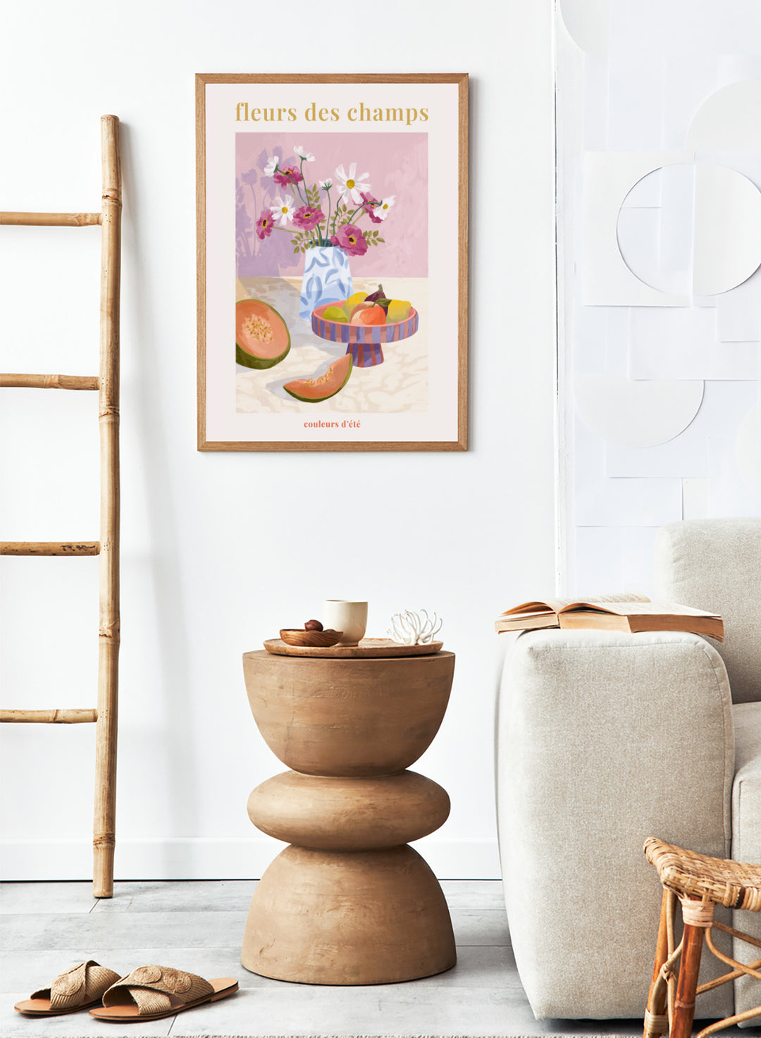 Illustration of a vase with flowers and fruits on a table against a pink background, with text 'fleurs des champs' and 'couleurs d'ete'. Fleur Des Champs Pink by Goed Blauw is a colorful still life art print and wall poster featuring flowers, fruit, and a patterned vase in a modern composition.