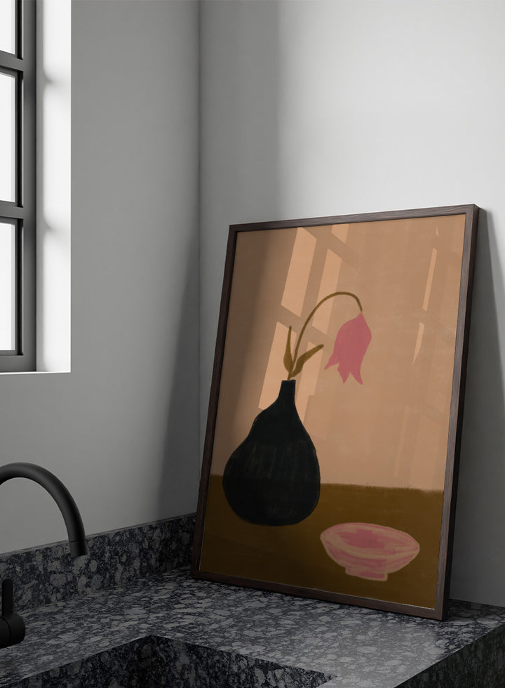 A minimalist still life painting featuring a black pear-shaped vase with a single drooping pink flower, alongside a pink bowl, set against a warm beige background and a brown tabletop. Minimal Pink Still Life by The Art Concept still life art print featuring a black vase, drooping pink flower, small bowl, and warm earthy tones.
