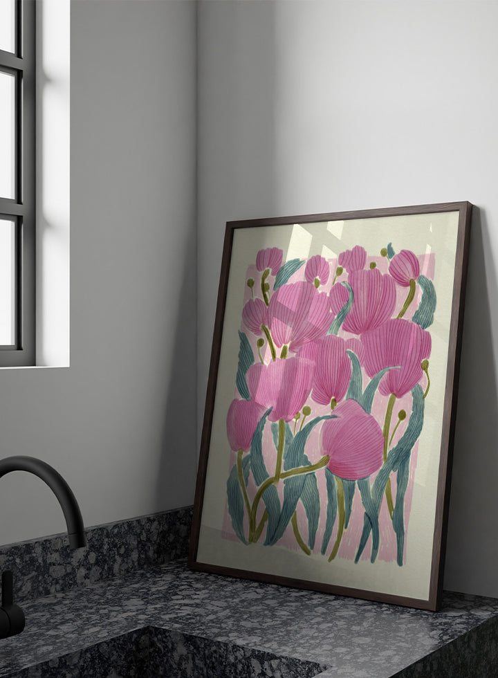 A framed art print featuring a stylized illustration of pink tulips with textured green leaves on a light cream background. Shop Pink Tulips by Katie O&