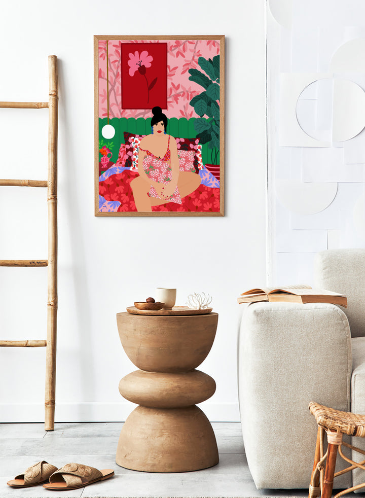 Illustration of a woman in a floral dress sitting on a bed with a colorful room setting. Floral Interior by Rafaela Mascaro is a colorful contemporary art print featuring floral patterns, lush houseplants, vibrant interiors, and joyful home decor inspiration.