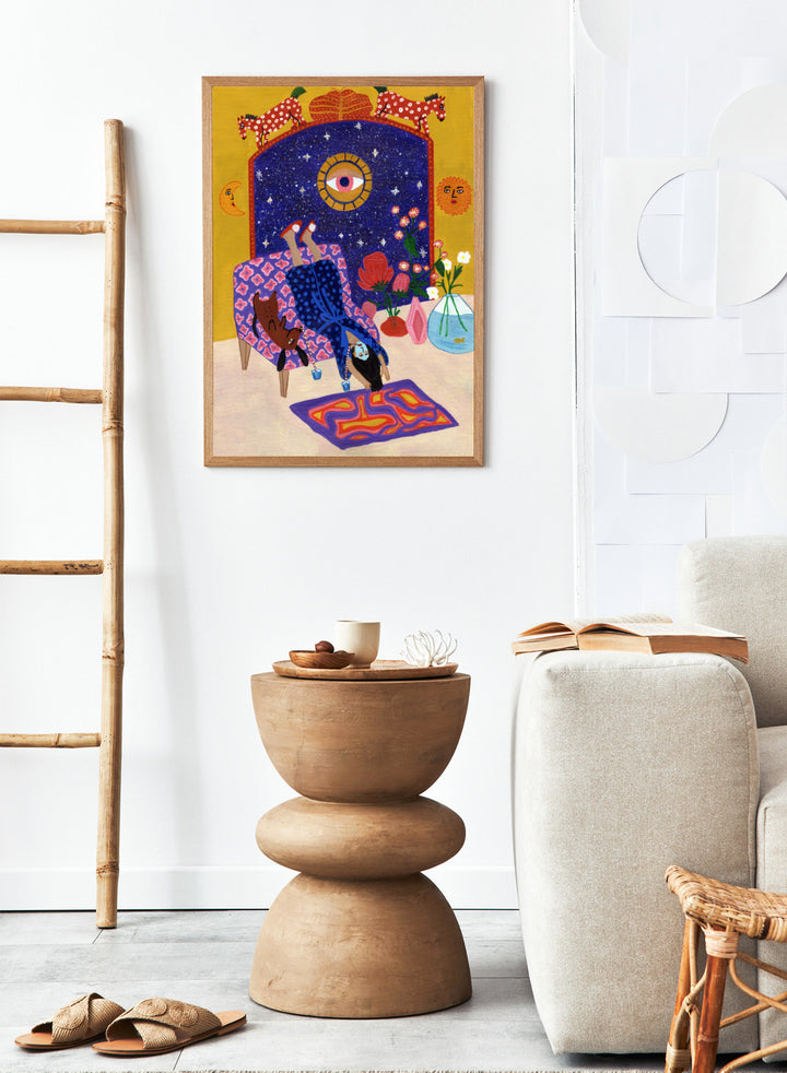 Colorful artwork of a person sitting on a chair with animals and decorative elements. Day Off From Office by Jota de Jai is a whimsical modern art print of a woman upside down with her dog, mid skincare routine, officially licensed wall poster with framing.