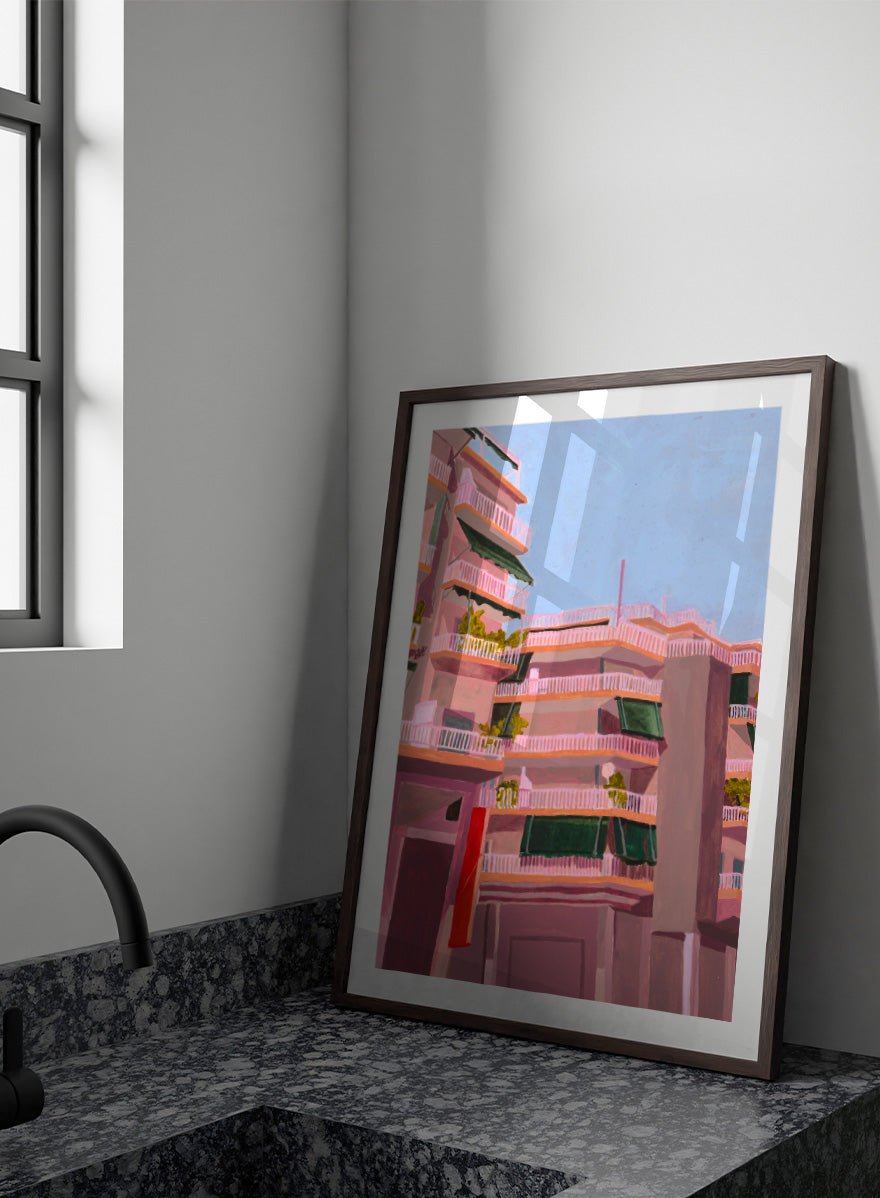 Shop Pink City Balconies by Sophia Novosel, a colorful city wall art print poster featuring pink apartment buildings, green awnings, balconies, and blue sky.