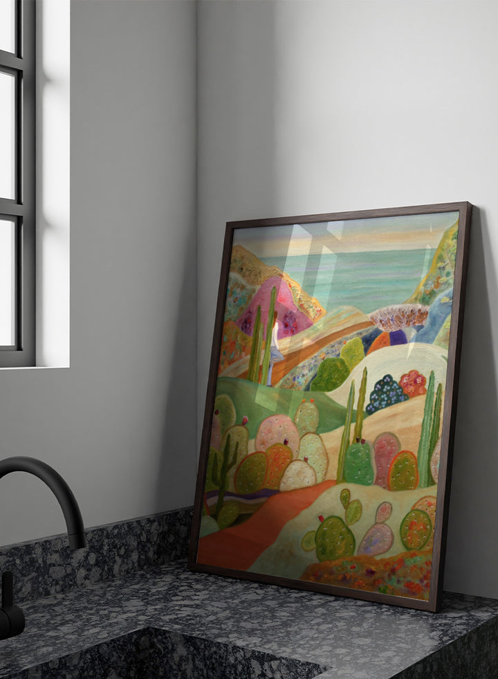 A colorful landscape painting featuring stylized cacti and succulents in a desert valley, with rolling hills, a pink mountain, and a blue sea or sky in the background. Shop Colorful Desert Yoga View by Angeles M. Pomata, a colorful desert landscape art print featuring cacti, rolling hills, a yoga figure, and coastal views.
