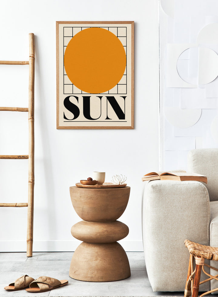 Poster with a large orange circle and the word 'SUN' on a beige background. Sun by Rosi Feist is a bold minimalist Bauhaus-inspired art print featuring an orange circle and graphic grid. Officially licensed modern poster with framing.