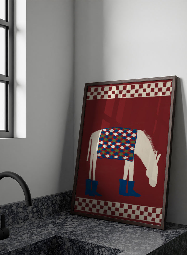 A stylized folk-art illustration of a white horse with a patterned blue, green, and red saddle blanket and blue boots, set against a dark red background with cream-and-red checkered borders at the top and bottom. Whimsical Donkey In Boots by The Art Concept animal art print featuring a white donkey in blue boots with a patterned blanket and rich red background.