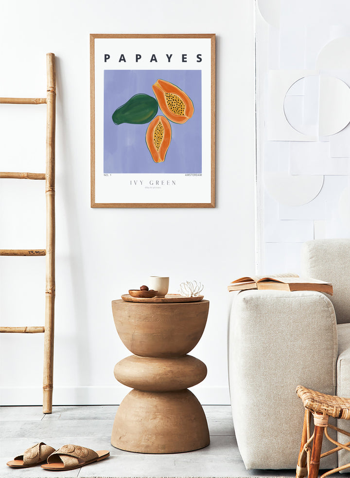 Illustration of papayas and a leaf on a blue background with 'Papayes' text at the top. Papayes by Ivy Green fruit art print featuring papaya illustration, modern food poster design, and colorful contemporary kitchen wall art.
