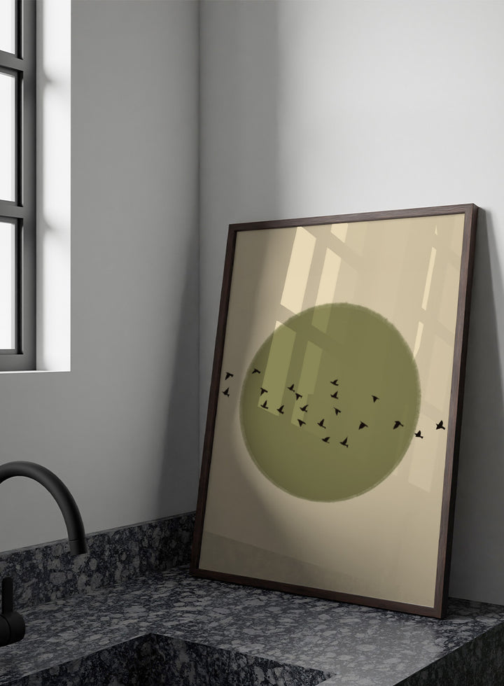Minimalist art print featuring a large olive green circle with small black bird silhouettes flying across it, set against a warm beige background. Graceful Birds Soaring by The Art Concept is a minimalist bird art print featuring black birds in flight across an olive green circle and warm cream background.